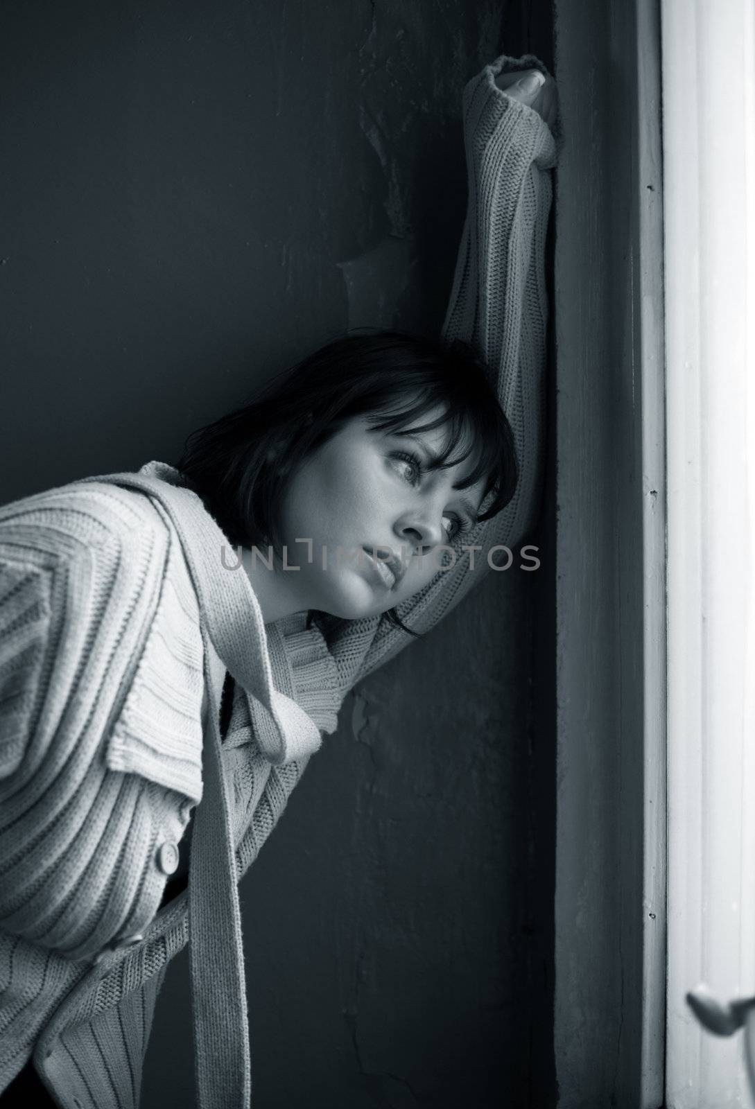 Beautiful sad brunette at a window