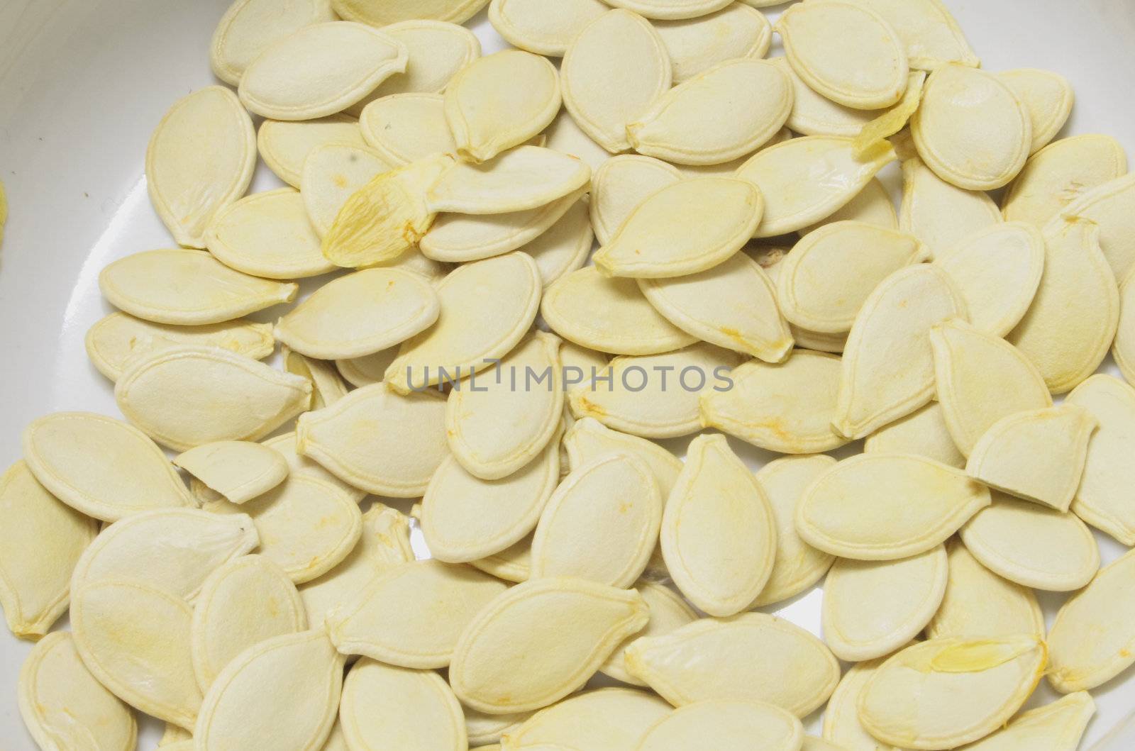 a whole lot of pumpkin seeds against a light background