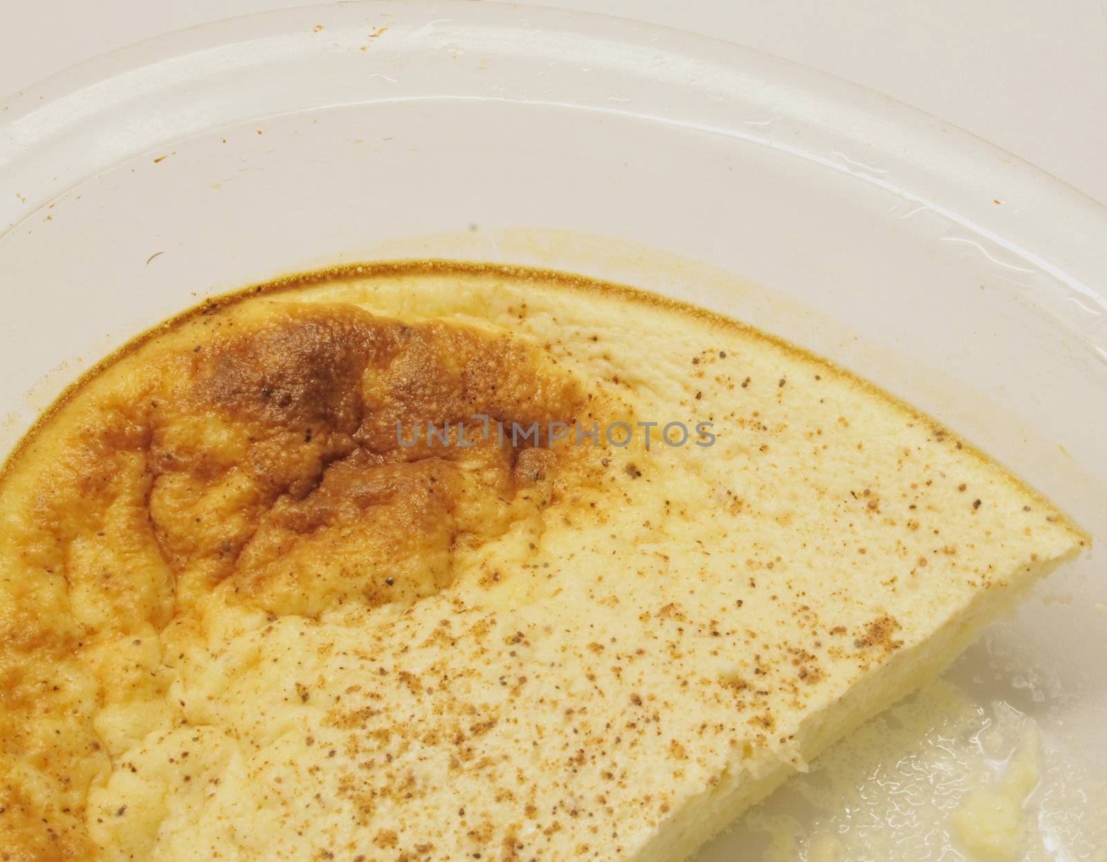 egg custard in a glass dish over alight background