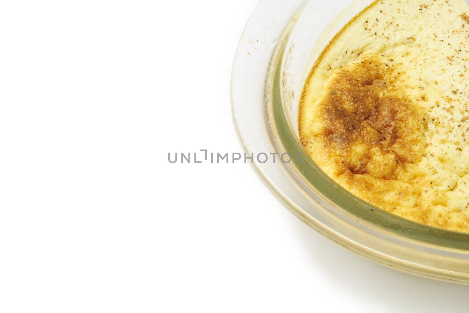 egg custard in a glass dish over alight background