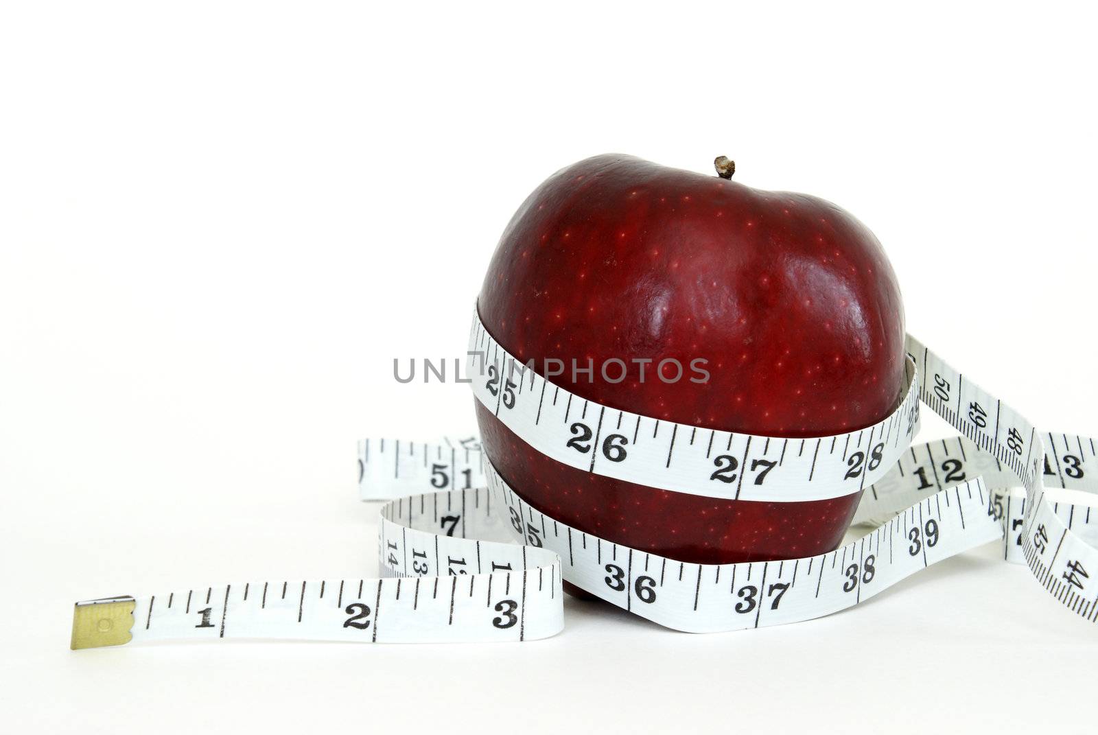 A red apple with a measuring tape wrapped around it for the concept of healthy eating.