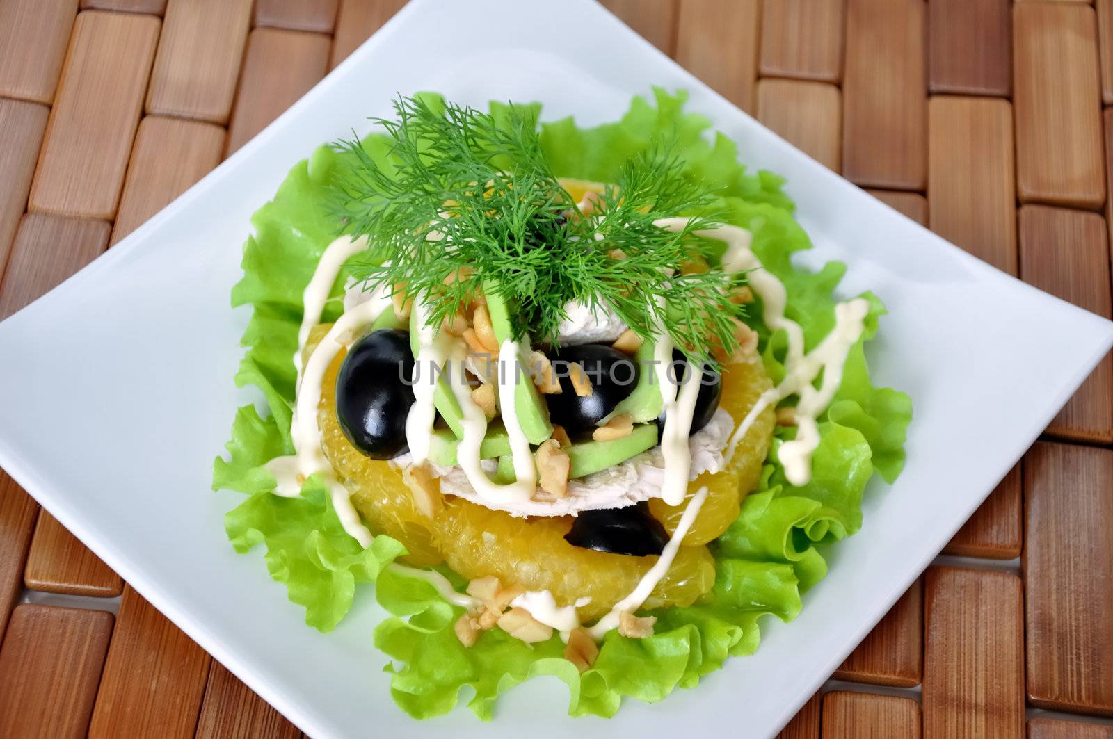 Appetizer of avocado, orange, black grape cream sauce sprinkled with peanuts