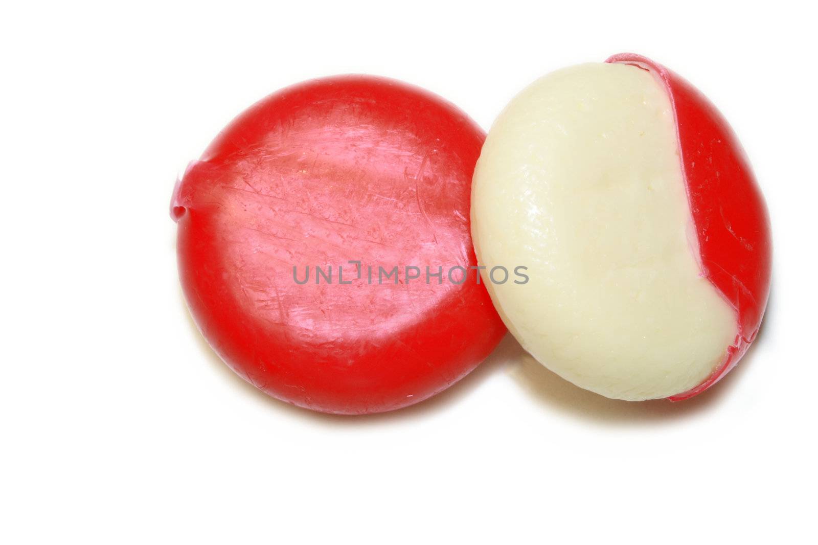 mini edam cheeses covered in red wax coating over a white background