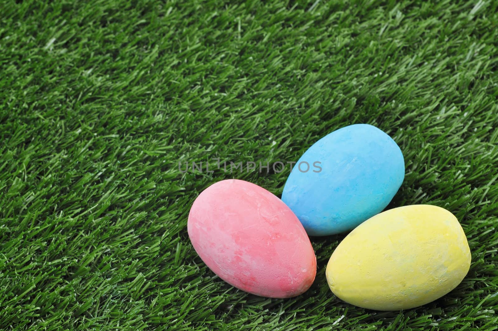Three Easter eggs on grass with copy space.