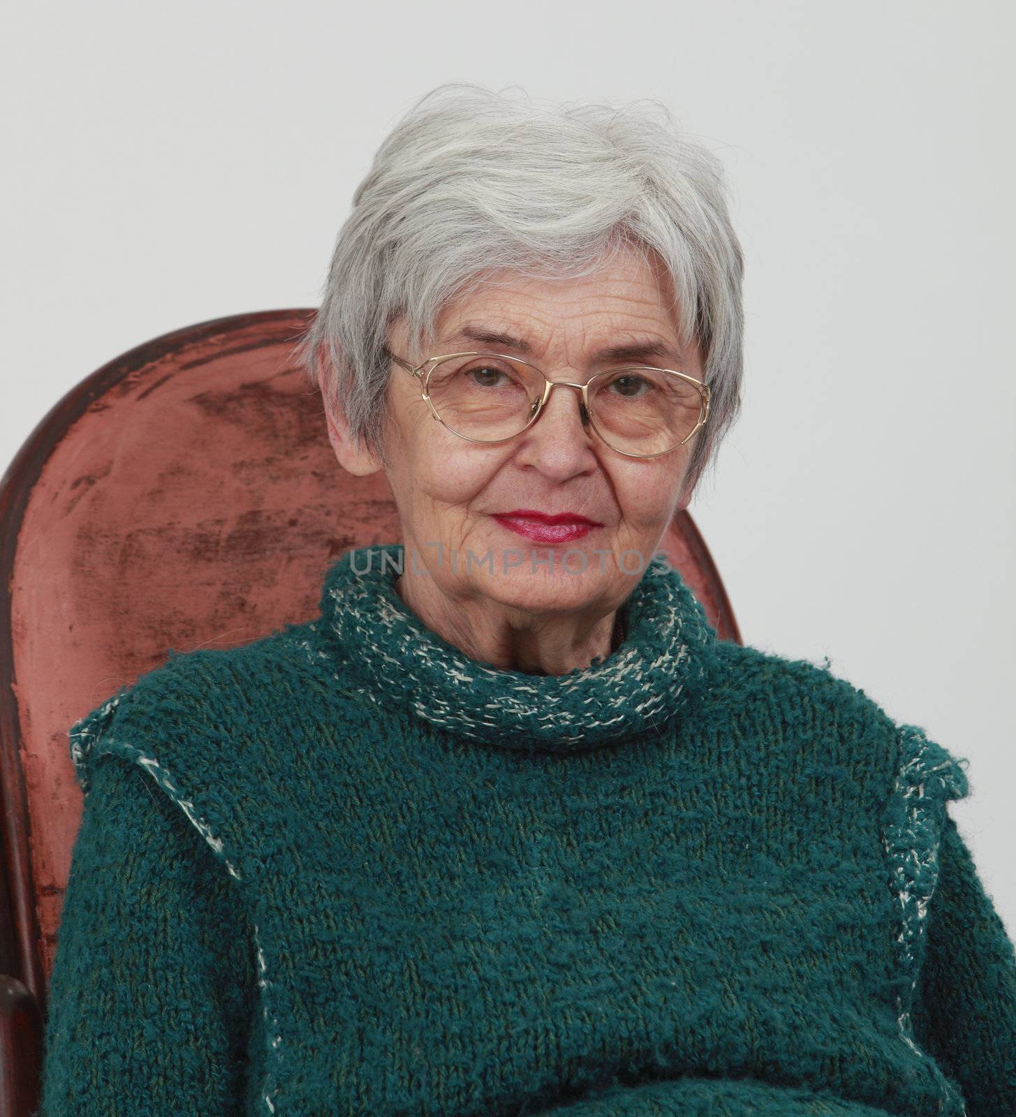 Portrait of an old woman against a grey background