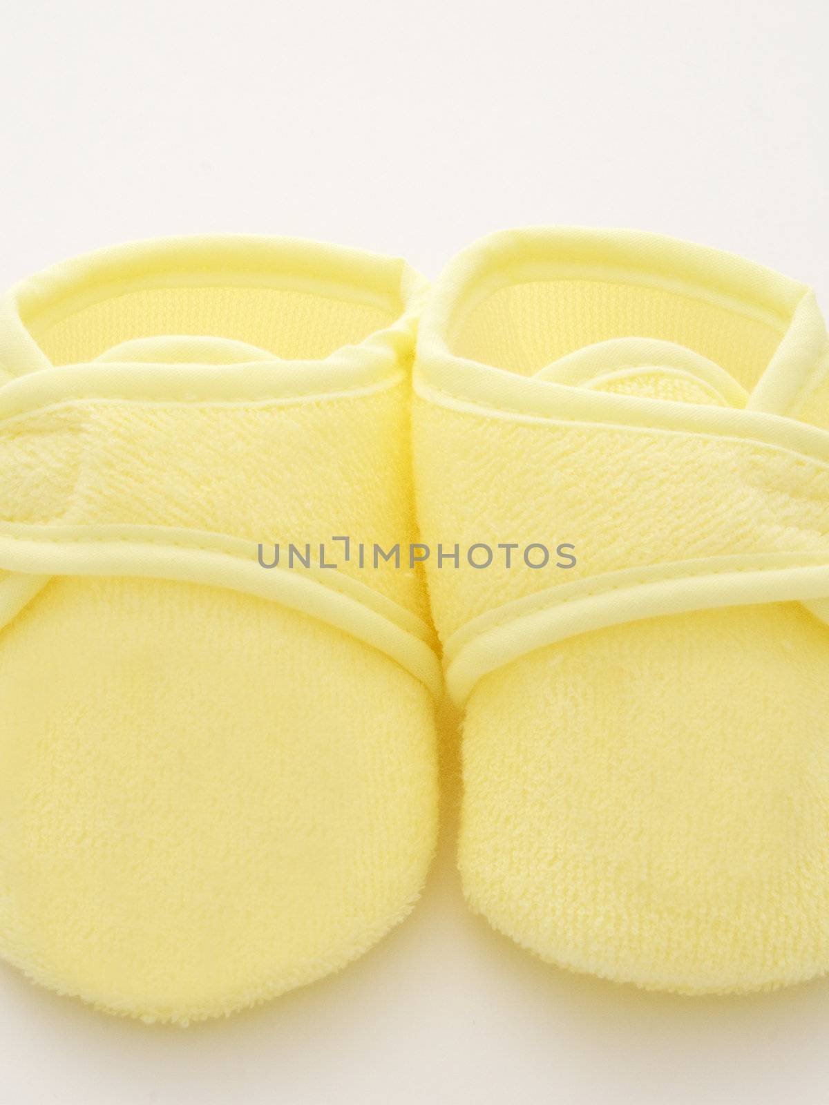 babies first pair of shoes in a yellow towelling material