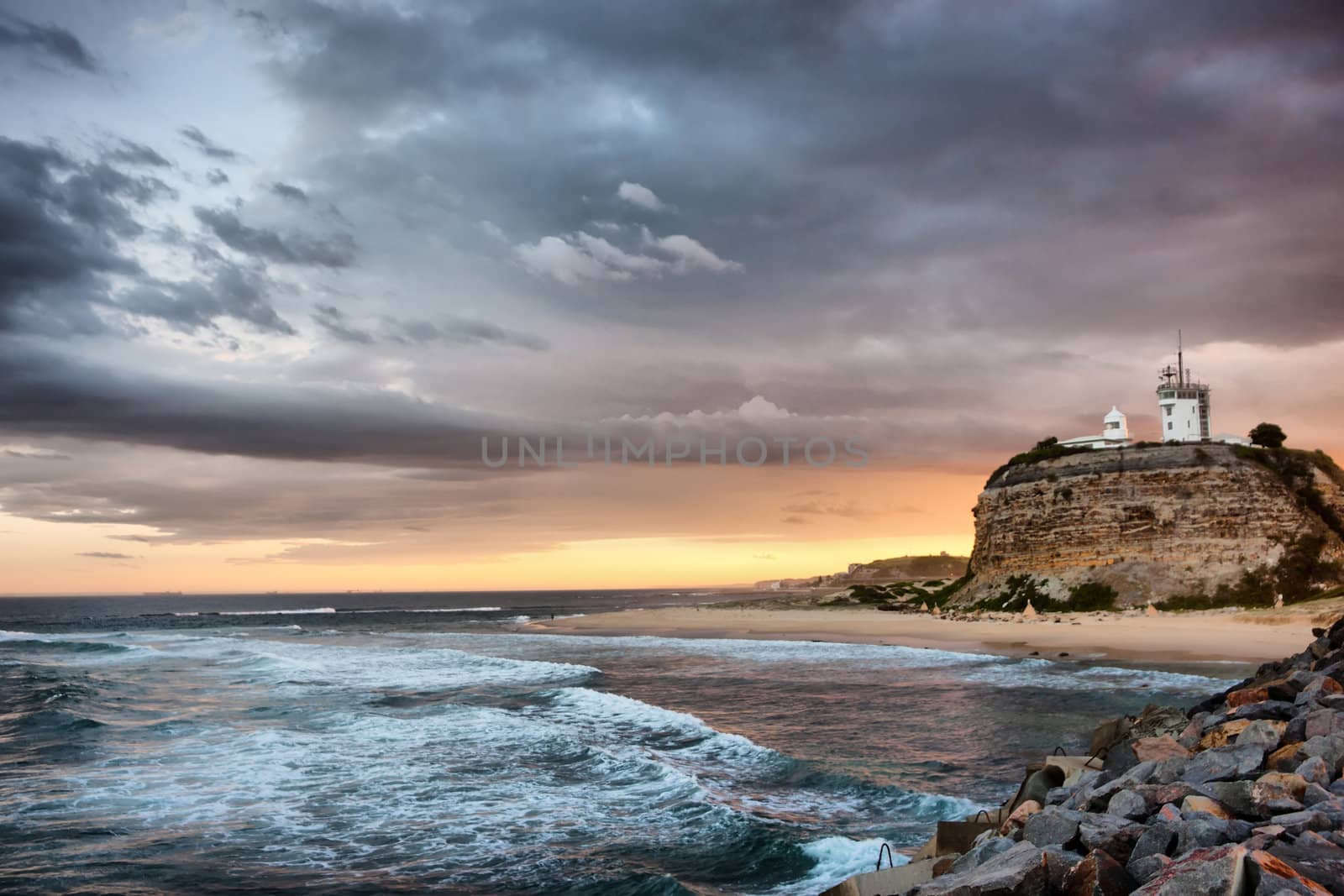 sunset on the ocean and lighthouse at newcastle 