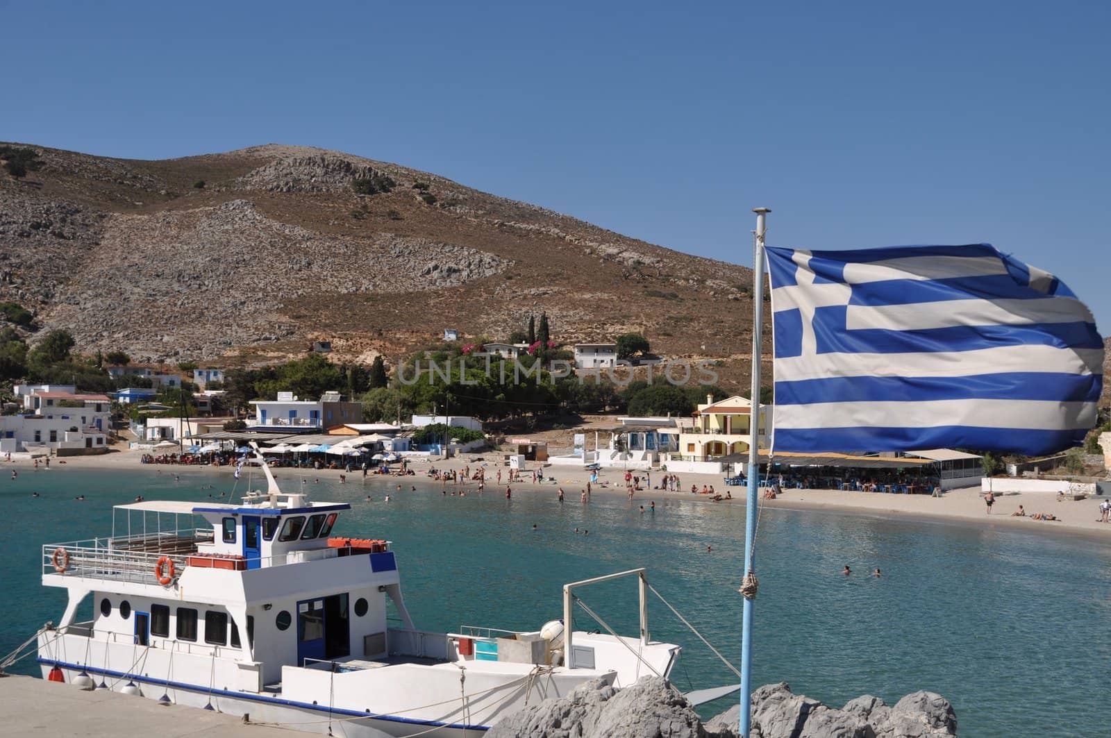 beautiful bay of Pserimos island with Greece flag