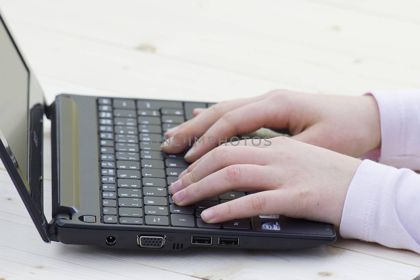 child hands typing on a keyboard of laptop 