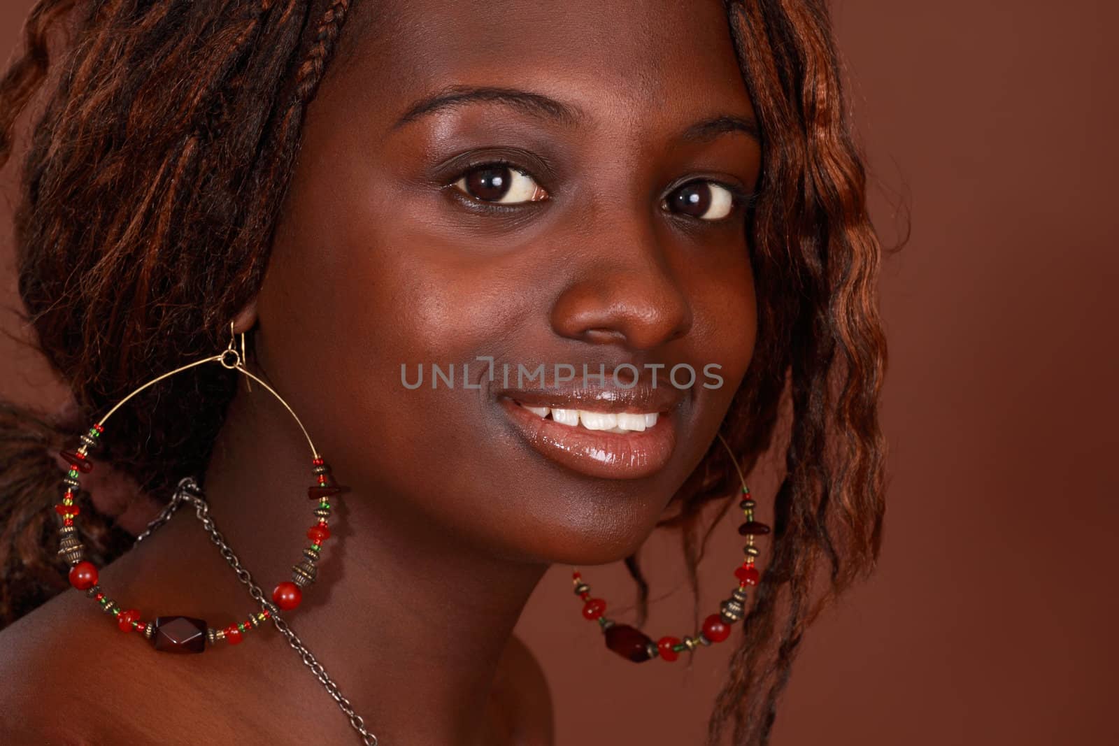 closeup portrait of a beautiful african girl, brown background