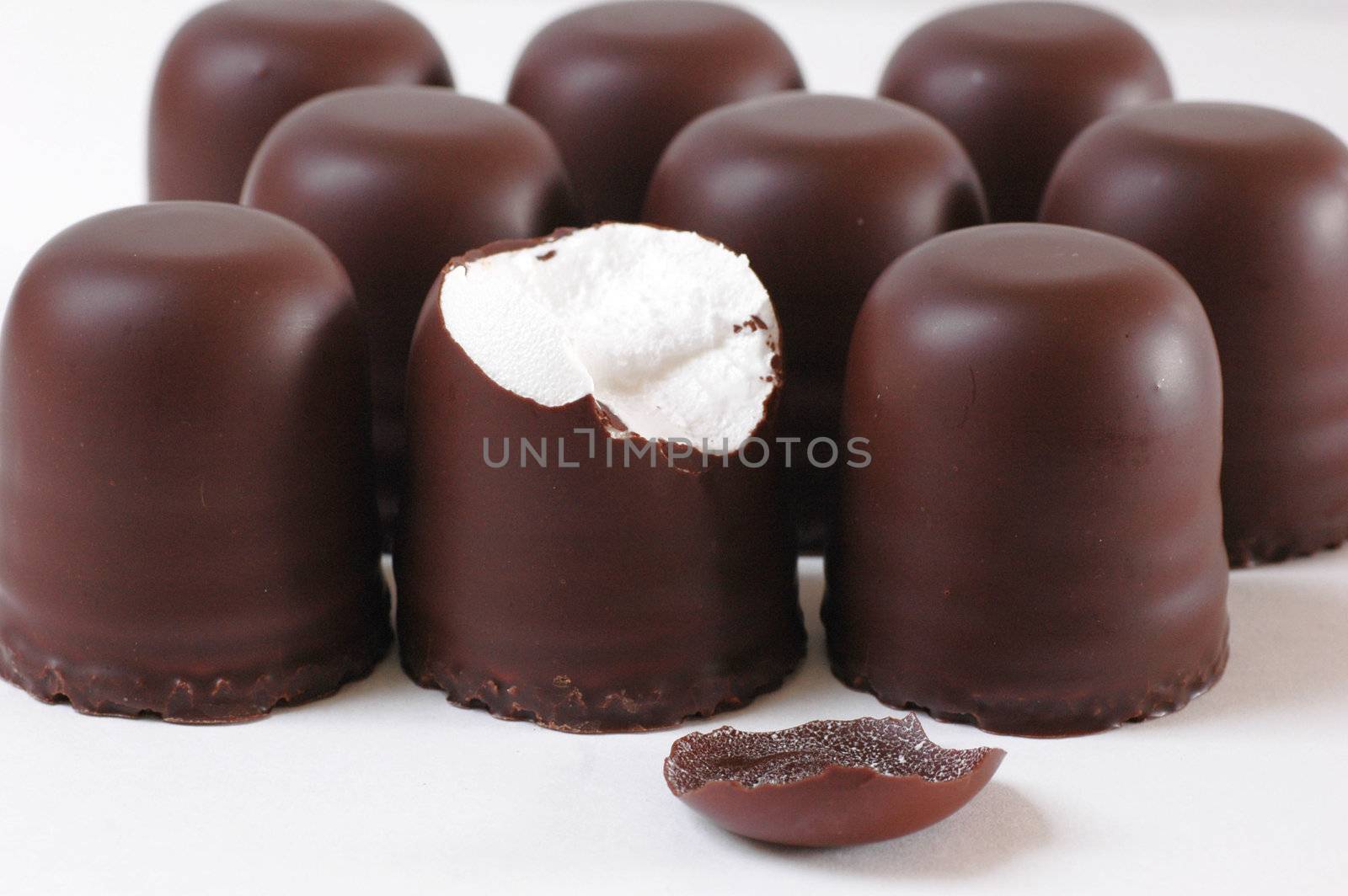 Nine chocolate marshmallows on a white background