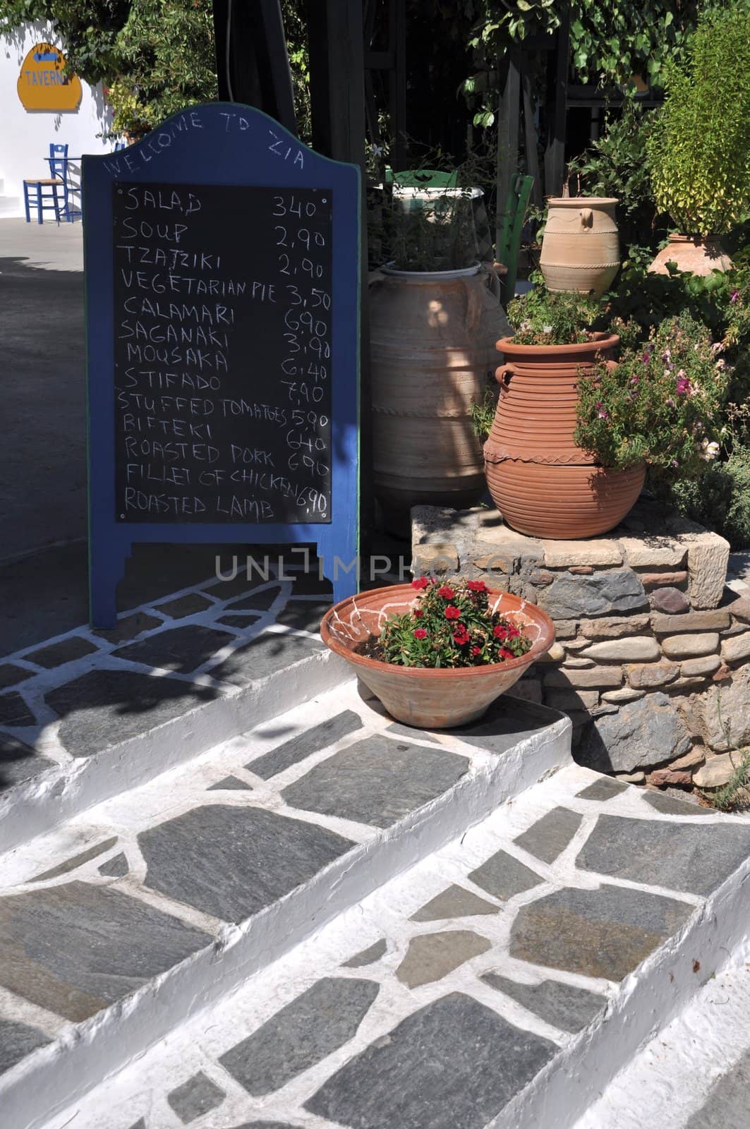 classic restaurant ad with a chalkboard menu and stone painted in Zia (Kos island), Greece