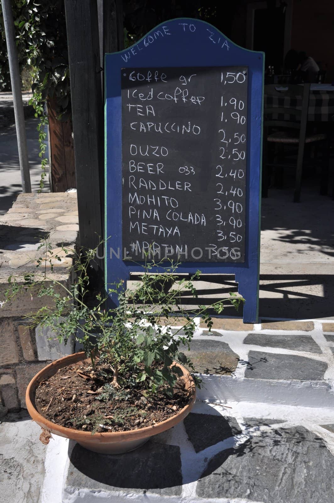 classic taverna ad with a chalkboard menu and stone painted in Zia (Kos island), Greece