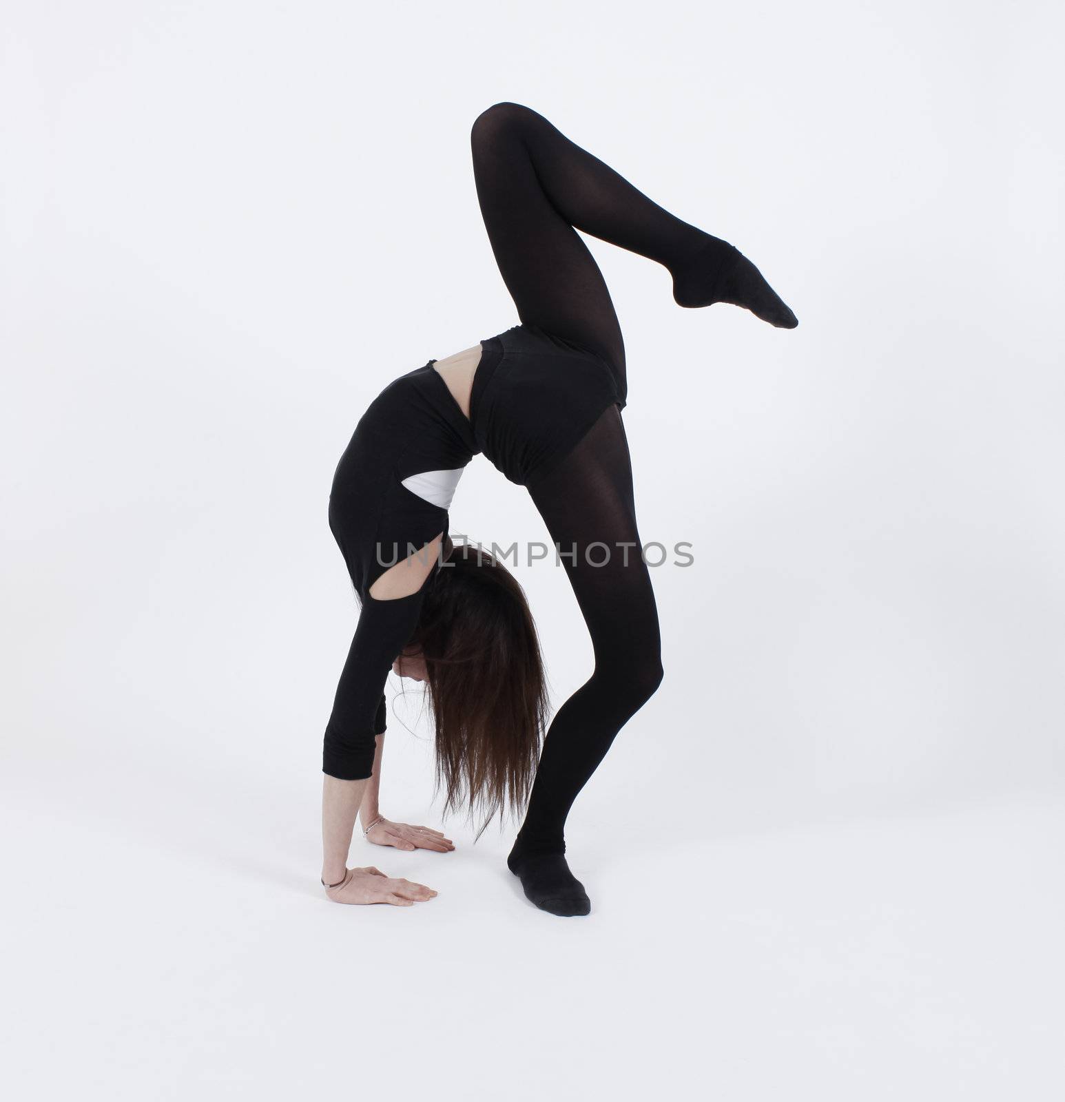 Young gymnast in black in studio with background