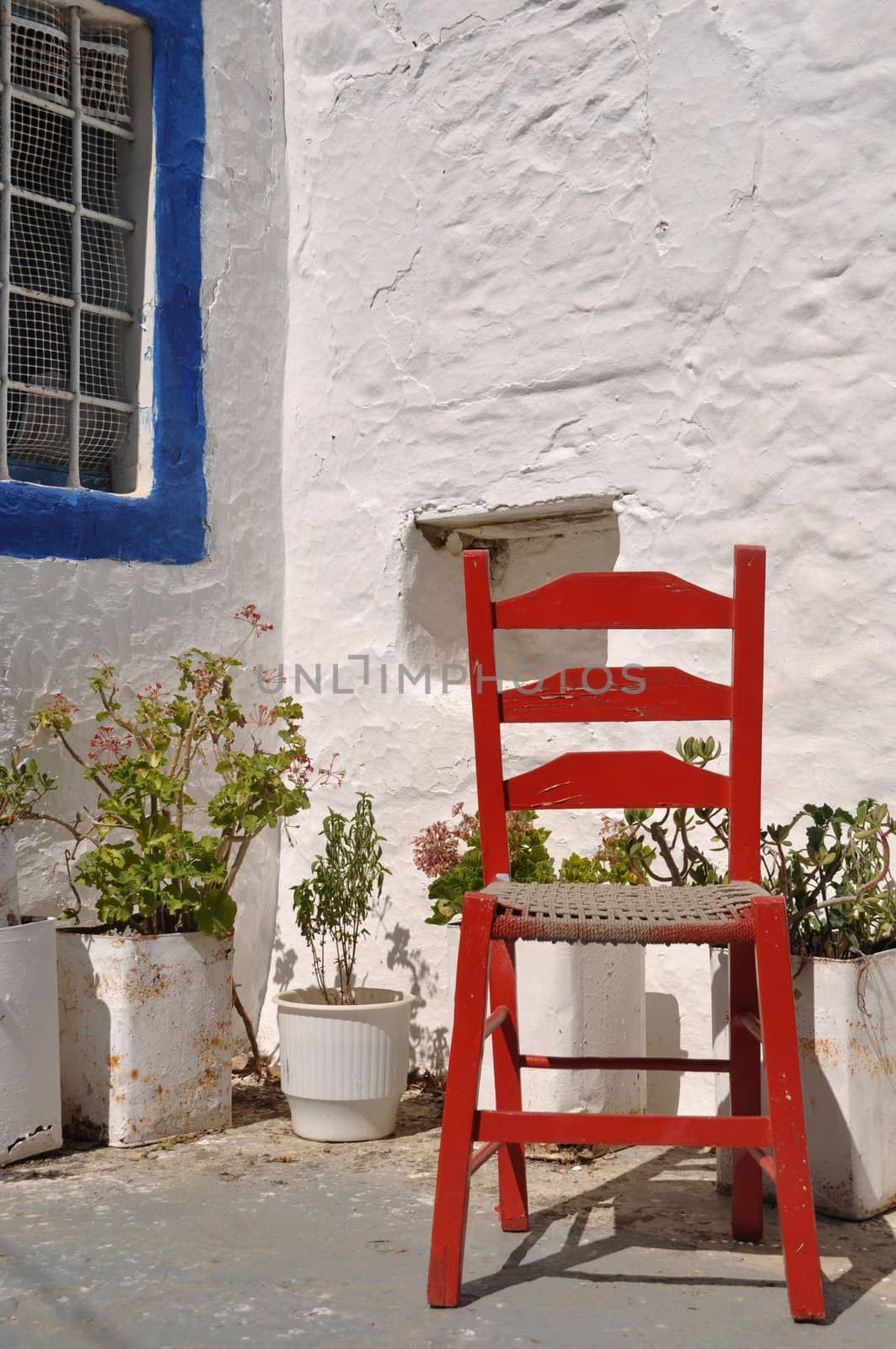 traditional greek house with red chair in Zia village (Kos), Greece