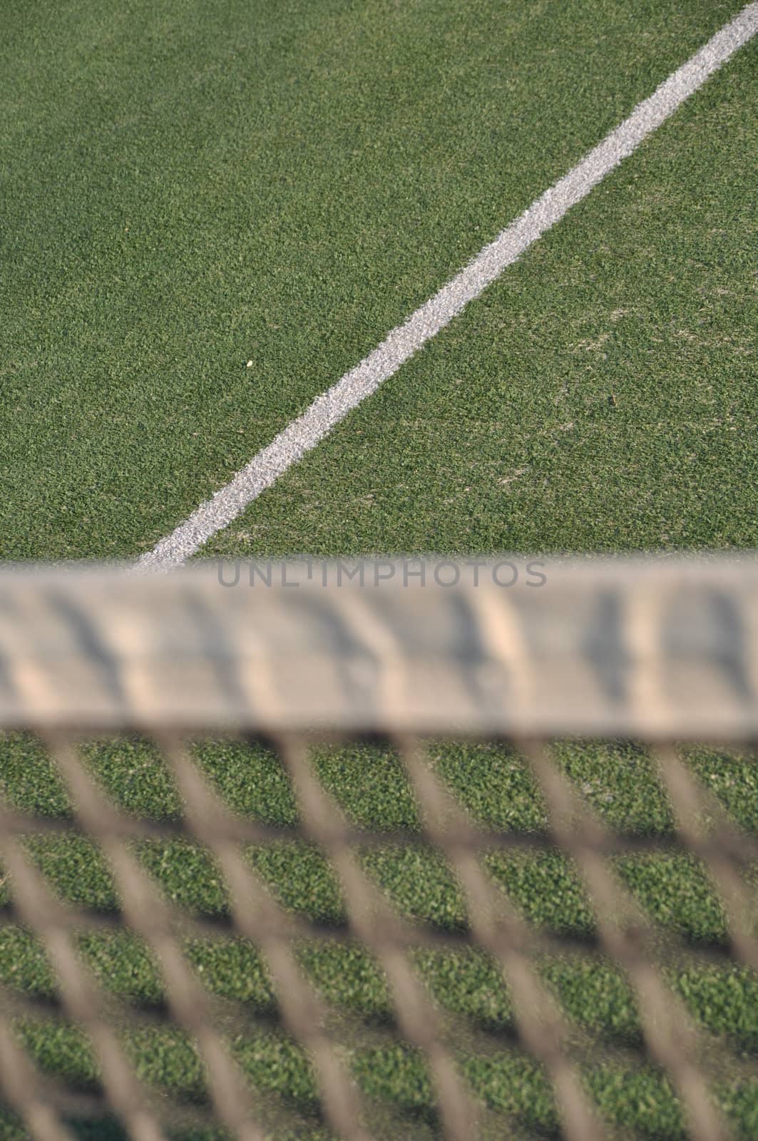 white line on an outdoor tennis court (defocused net)