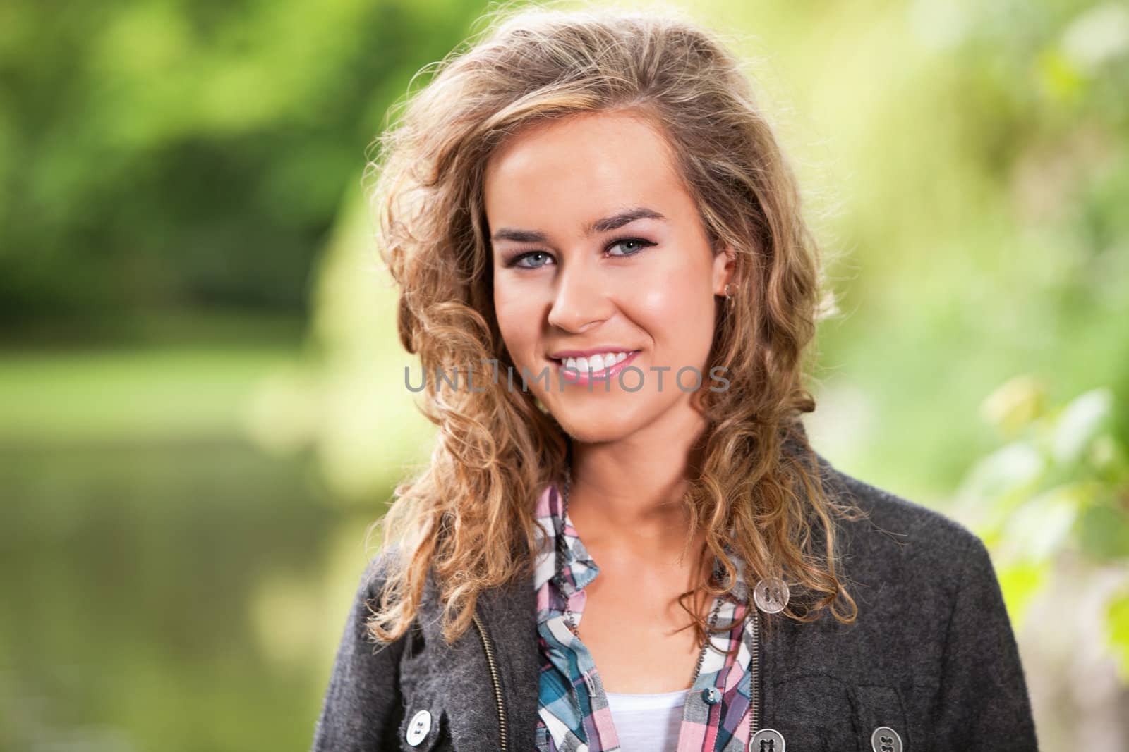 Happy blond female smiling by leaf