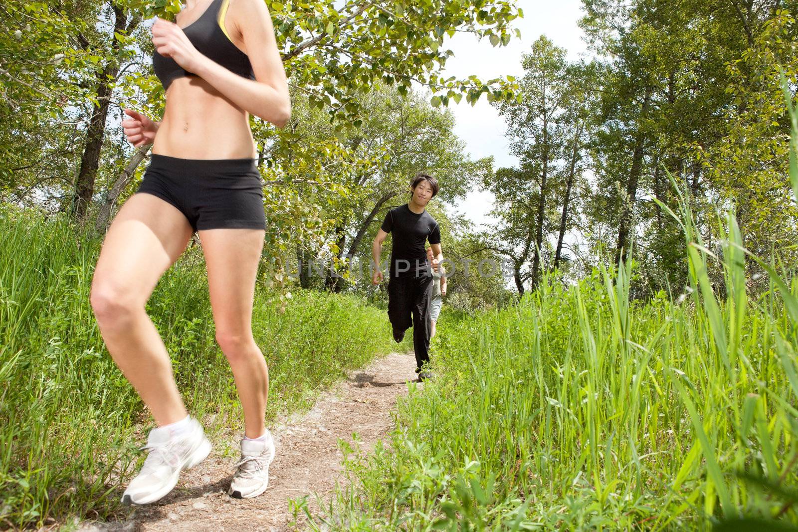 Healthy people jogging in forest by leaf