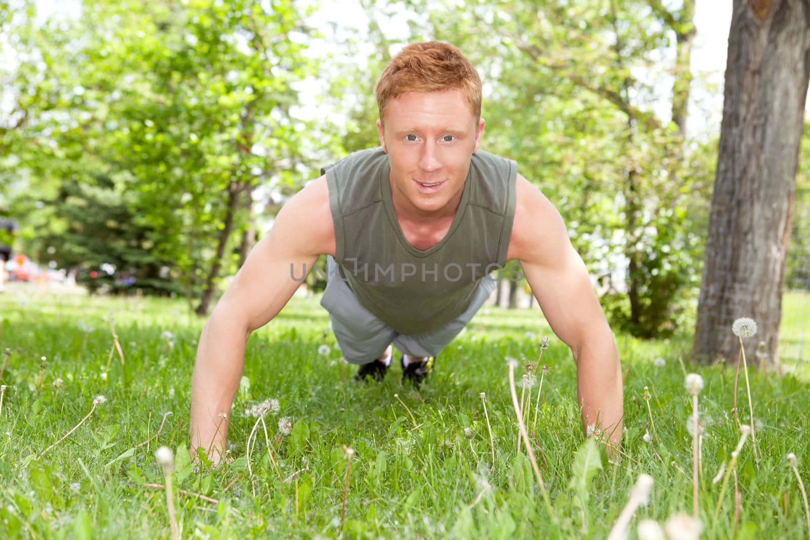 Man doing a push up in park by leaf