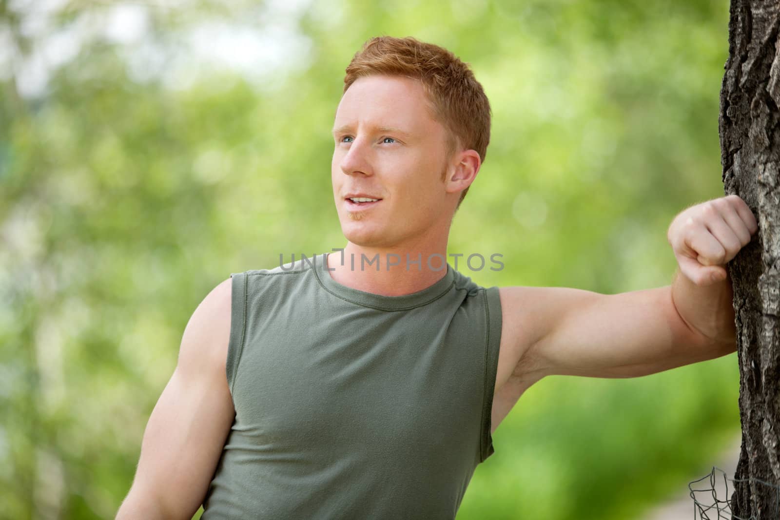 Man smiling and looking away by leaf