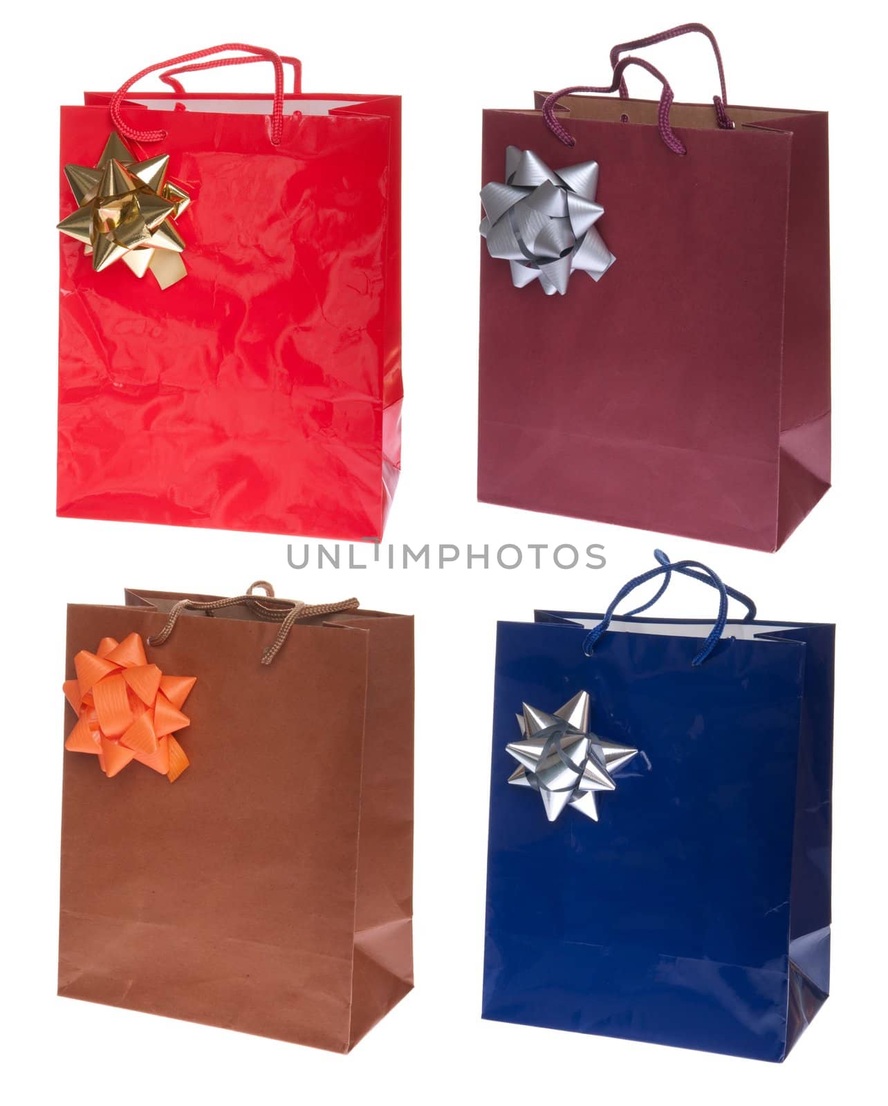 four colorful gift paper bags with bows isolated on white background