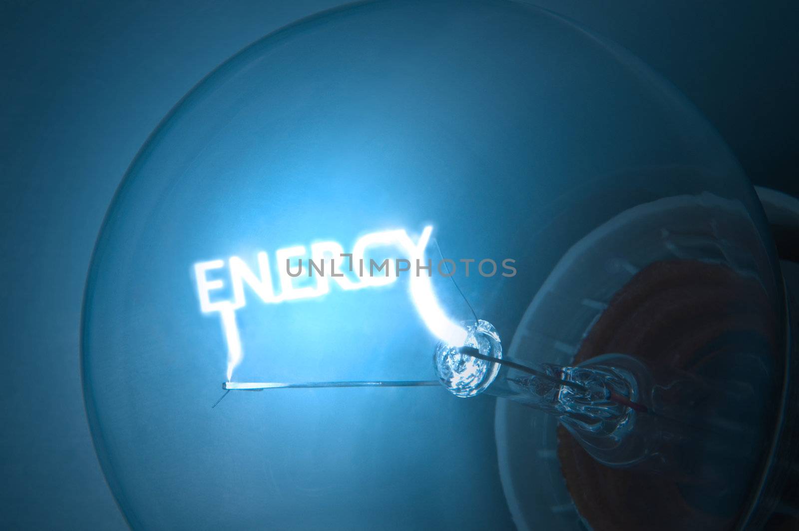 Close up on illuminated blue light bulb filament which spells the word "ENERGY".