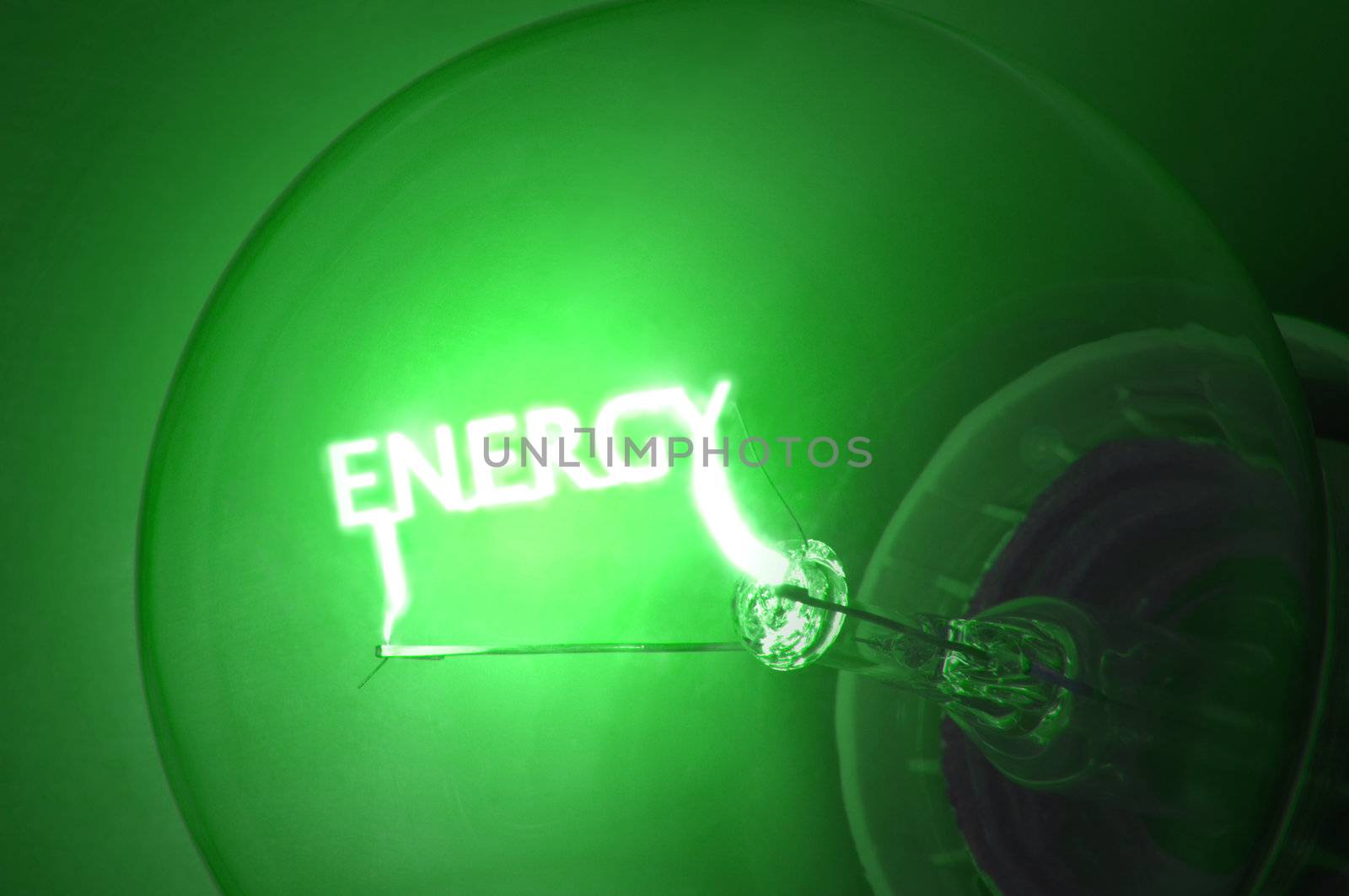 Close up on illuminated green light bulb filament which spells the word "ENERGY".