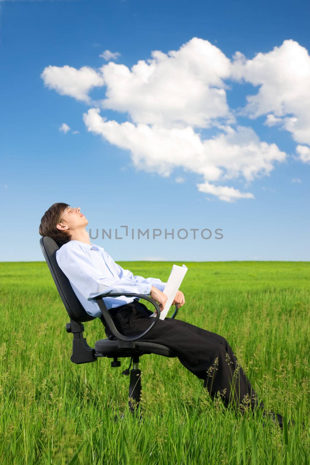 Businessman relaxing on grassland under blue sky by rozhenyuk