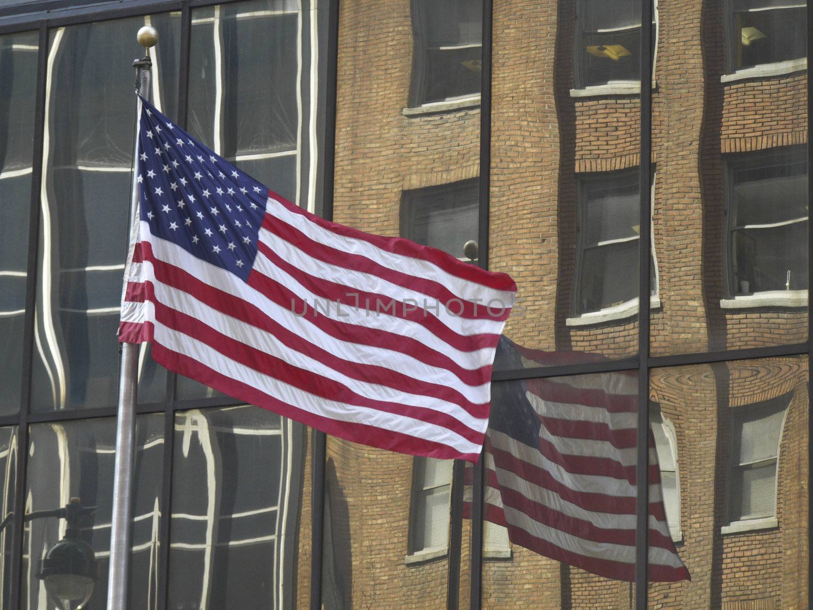 american flag with its reflection in a modern building