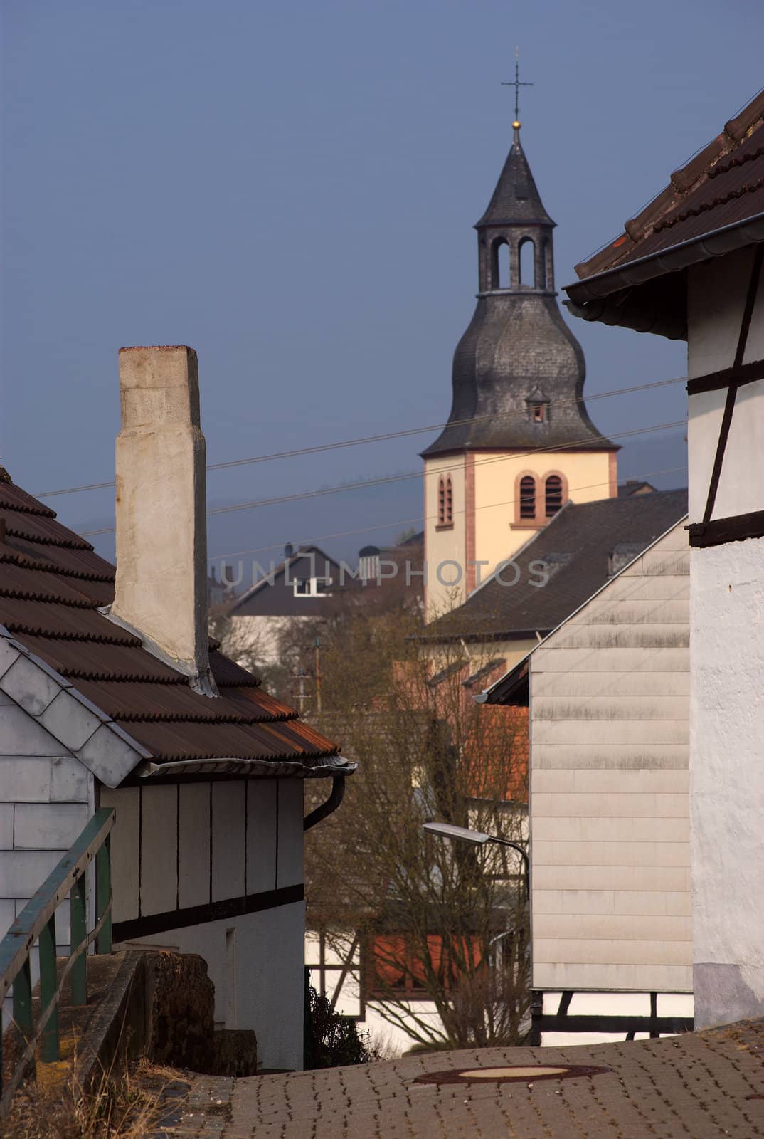 Belltower between traditional old houses in town Heimbach, Germany