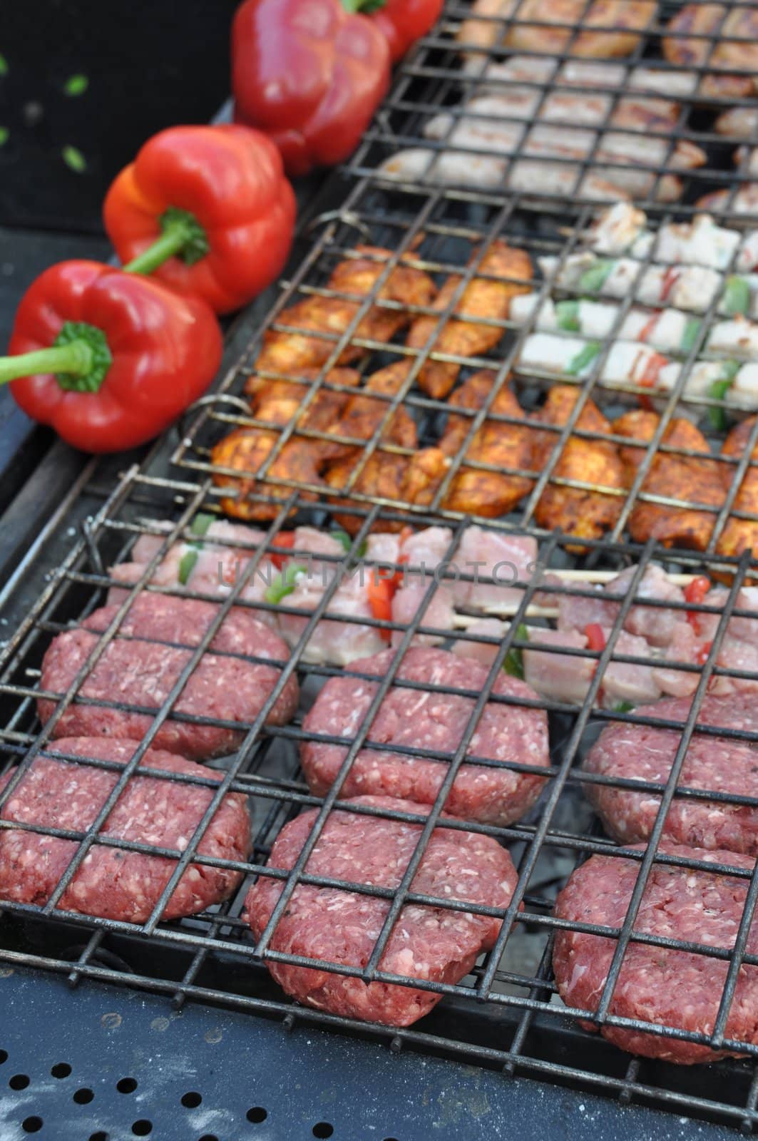 grilling fresh meat and peppers on a outdoor barbecue (shallow depth of field)