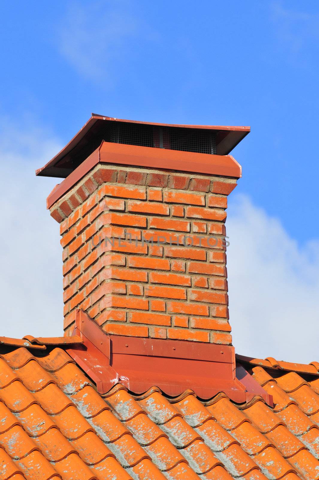 Red brick chimney on tile roof