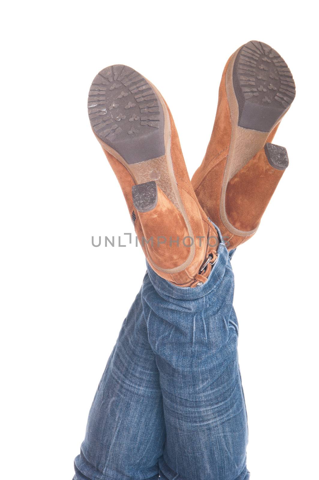 woman with legs up in jeans wearing leather fashion boots (isolated on white background)