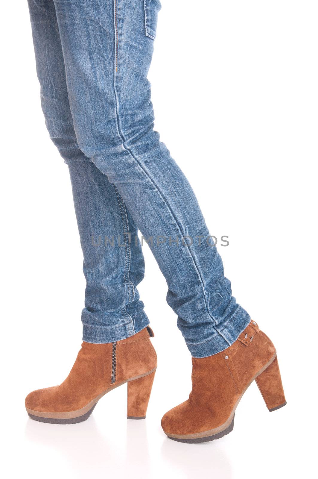 legs in jeans wearing leather fashion boots isolated on white background (walking pose)