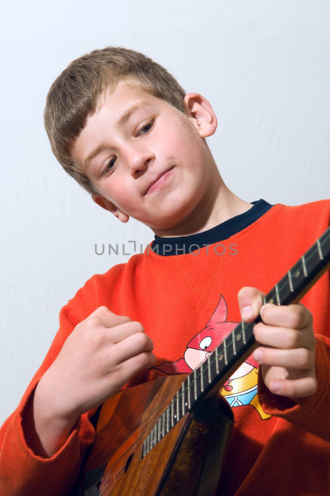 	
A boy plays balalaika Russian folk musical instrument