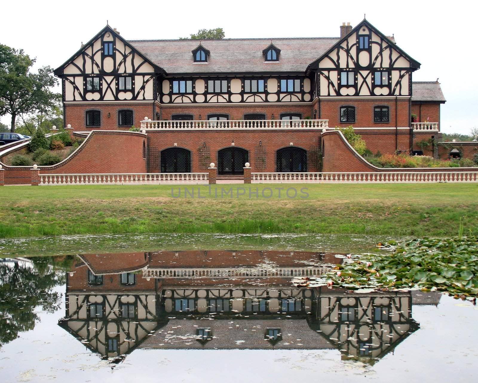 A Large Estate Home in the UK with Reflections in a Lake.