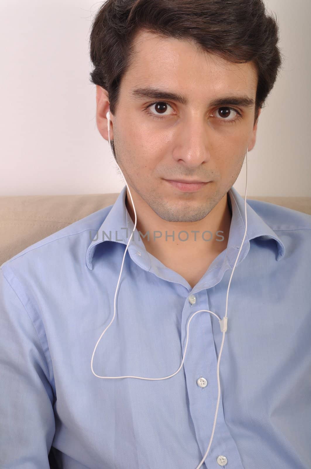 attractive young man listening to music on the couch