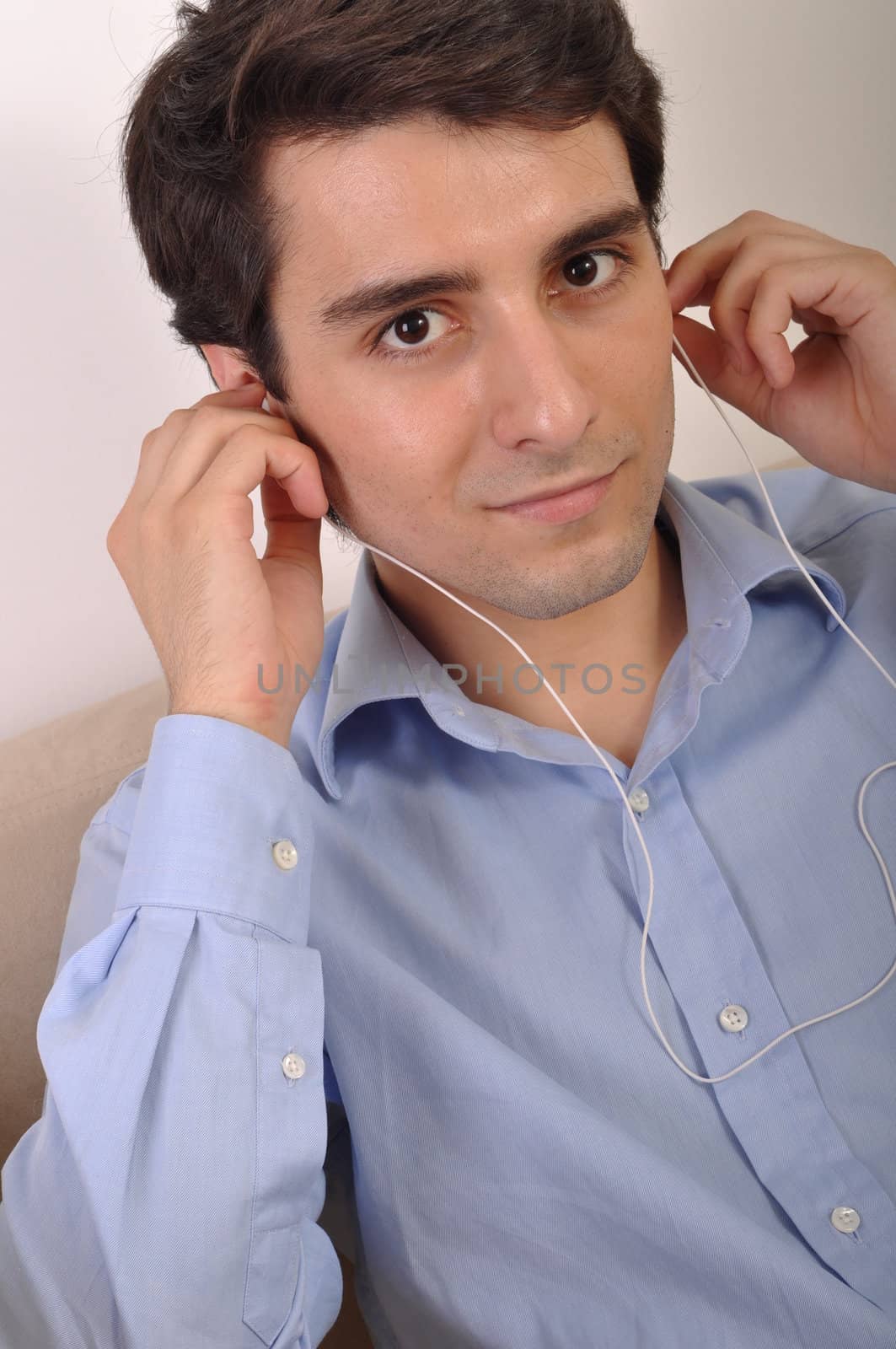 attractive young man listening to music on the couch