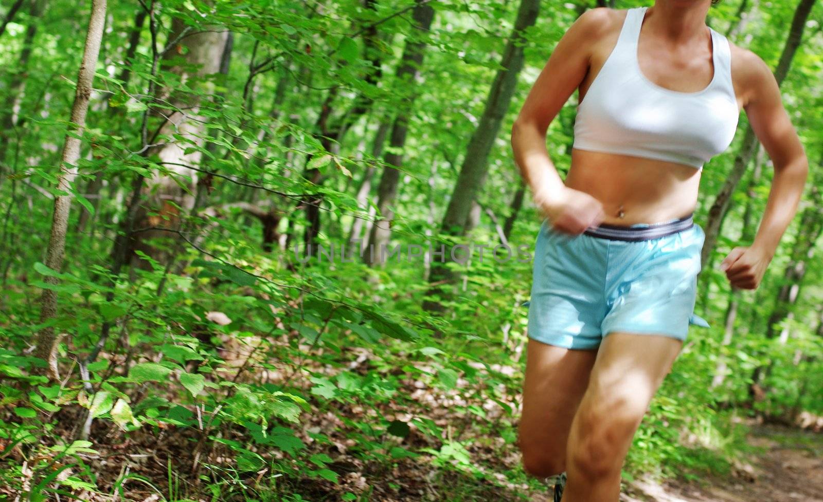 Mature woman running in forest.