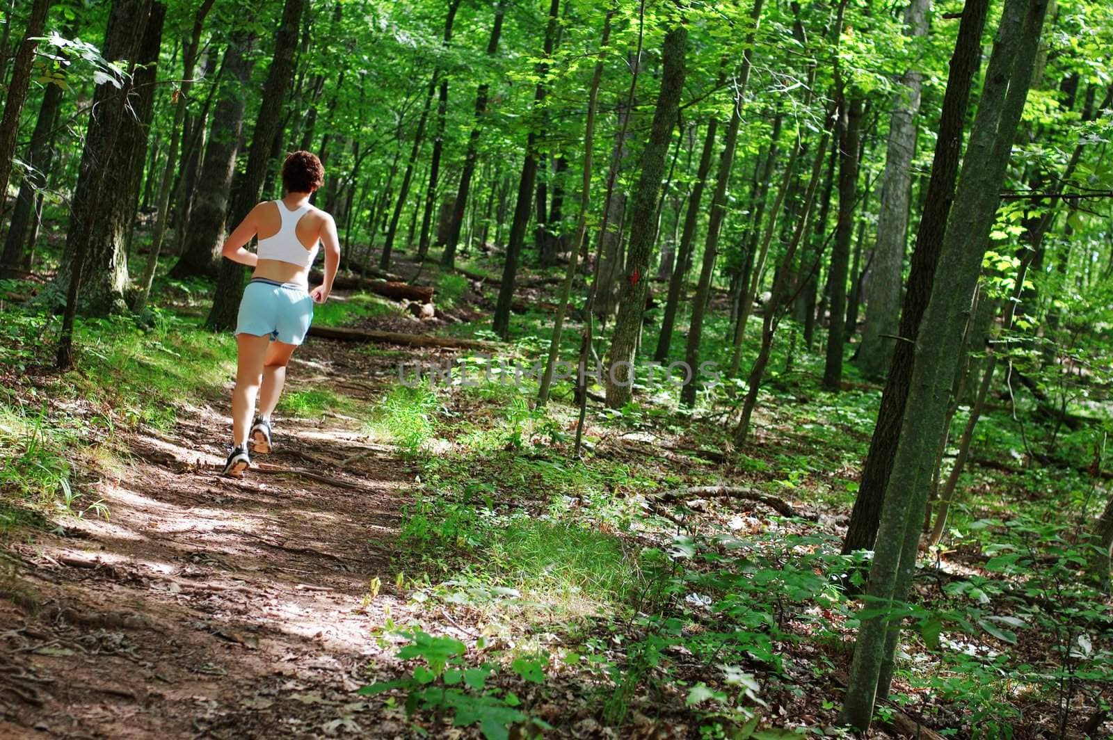 Mature woman running in forest.