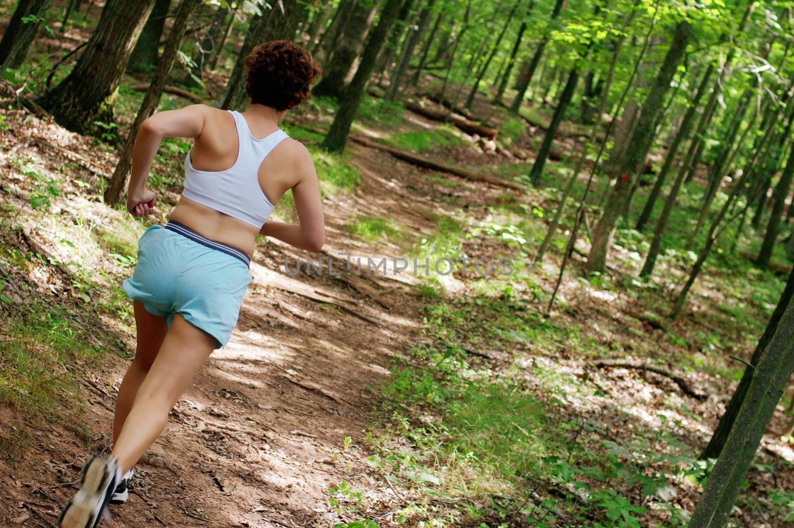 Mature woman running in forest.
