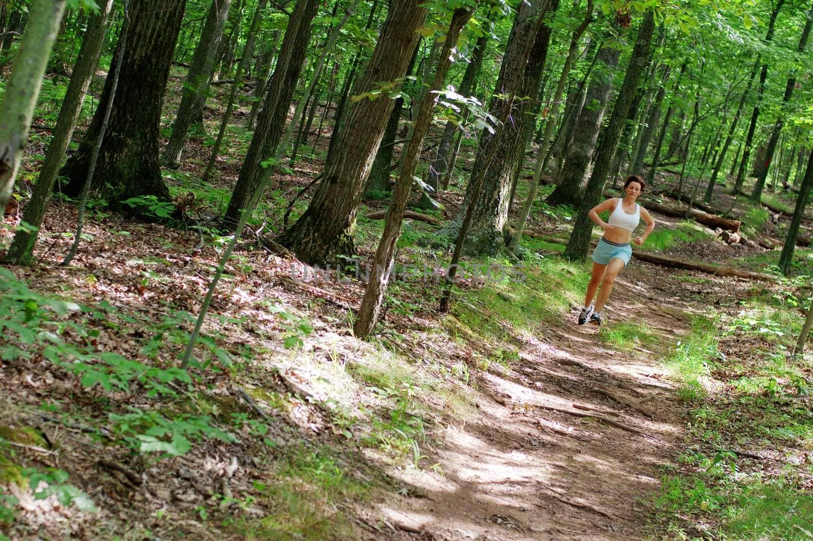 Mature woman running in forest.