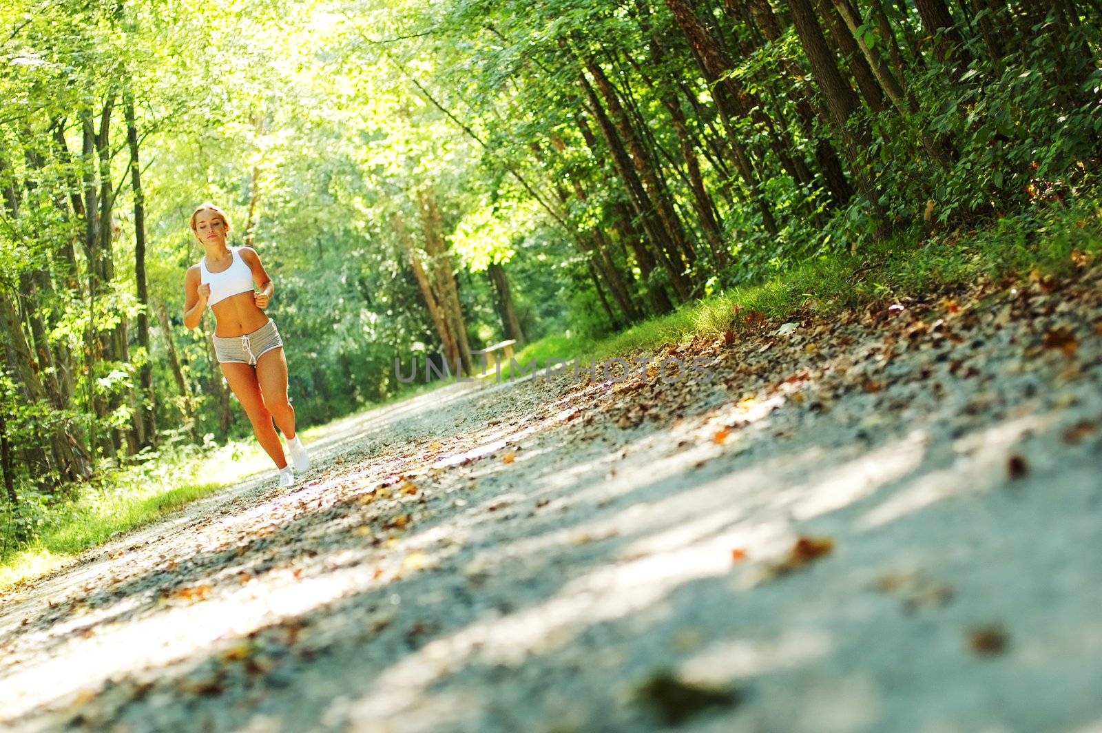 Pretty young girl runner in the forest.