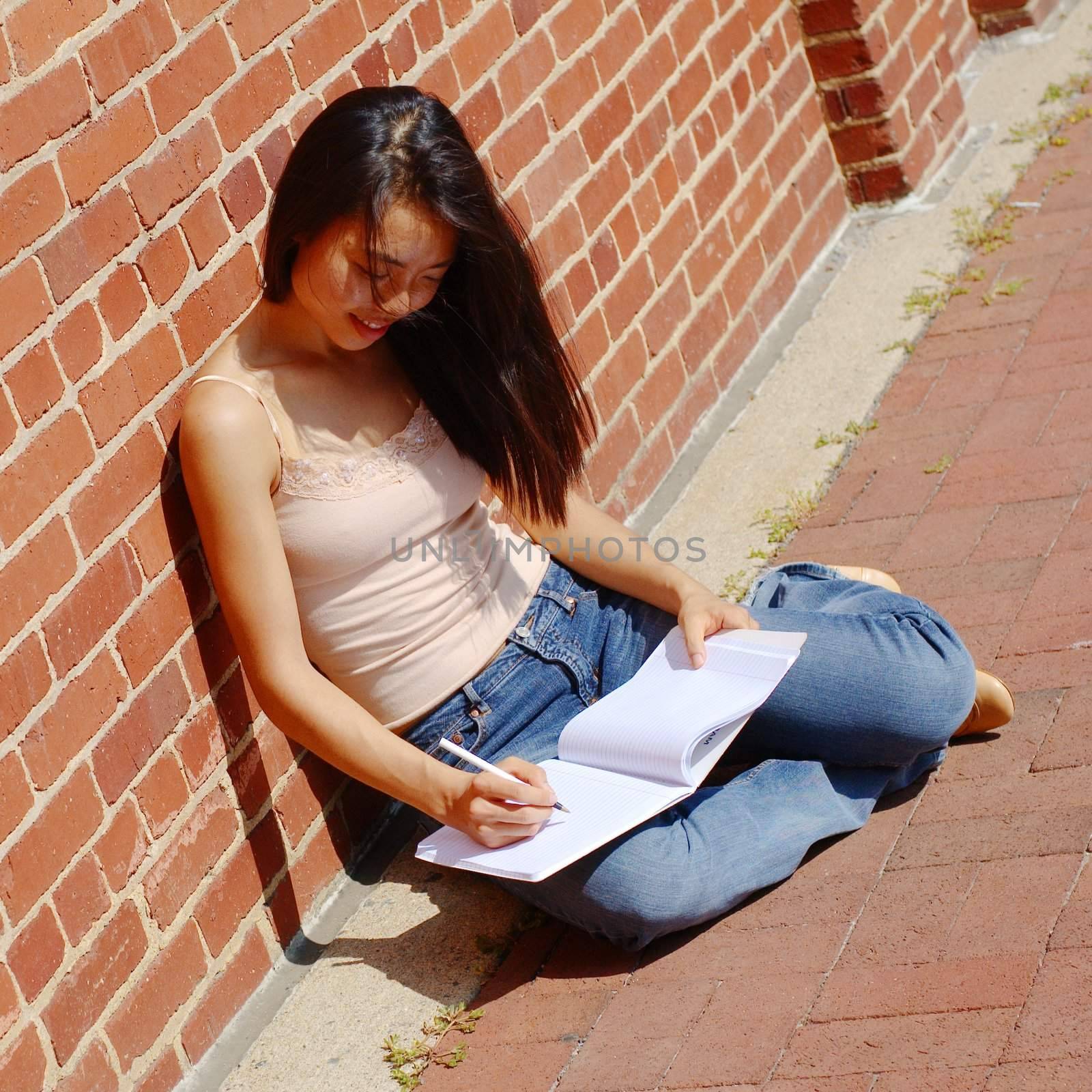 Girl writing in notebook in the city.