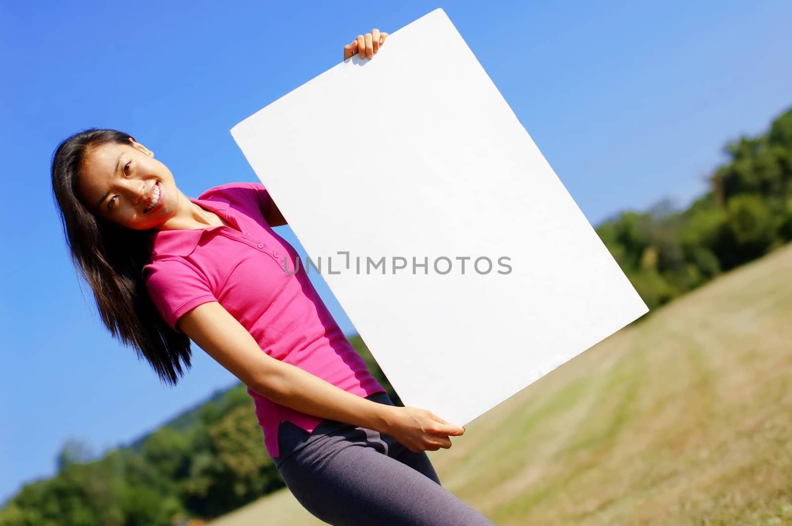 Happy asian girl holding a blank poster.