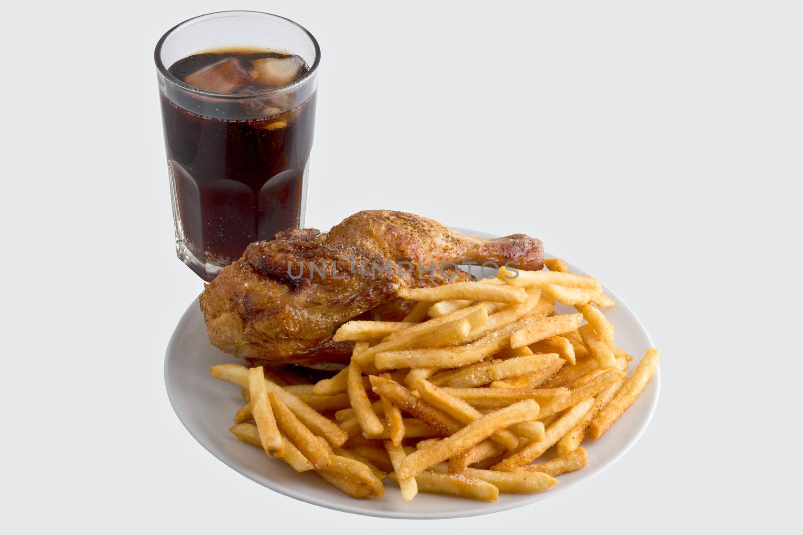 Plate fried chicken with french fries next to a cold cola. Isolated