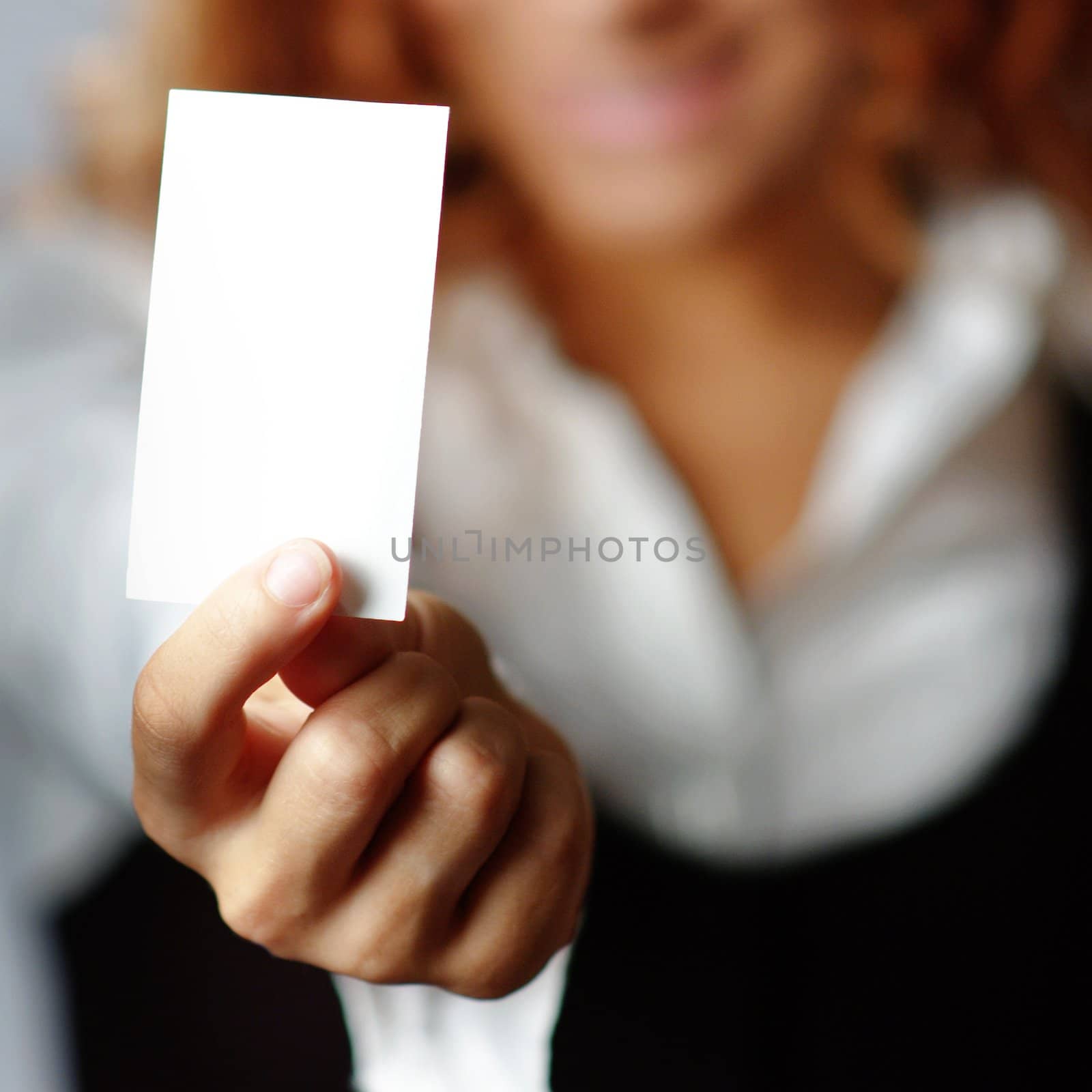 Pretty girl holding white blank media, against white.