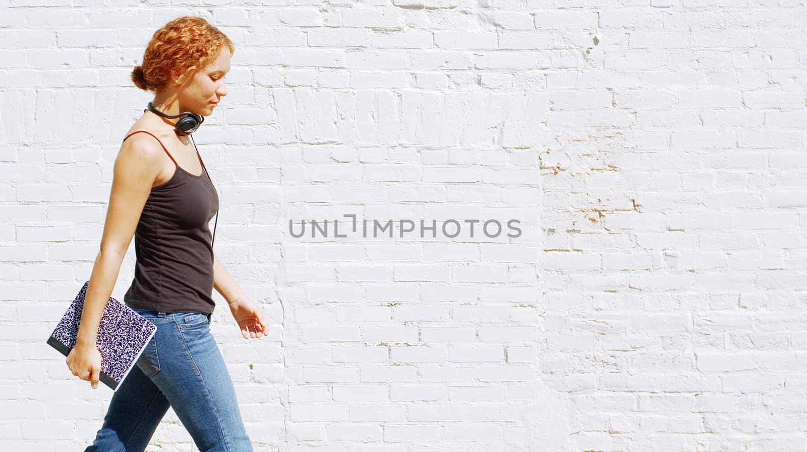 Attractive urban girl against white brick wall.