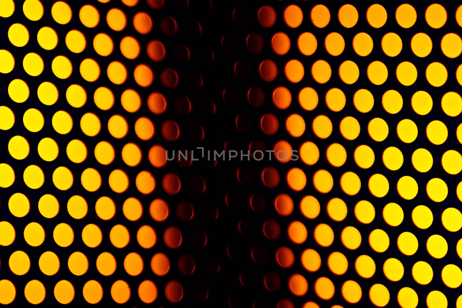 A metalic reflective surface back lit by a colorful light.