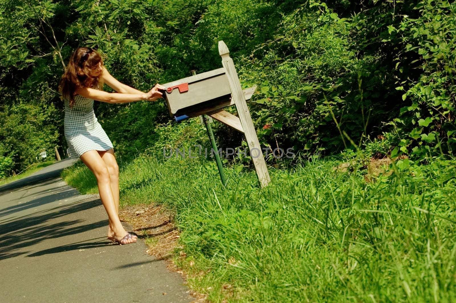 Pretty girl checking mail box for mail.